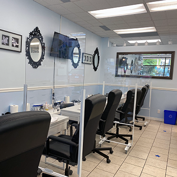 Plexiglass dividers between: spa pedicure chairs, manicure tables, nail drying stations and waiting area.